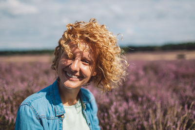 Portrait of smiling young woman standing on field