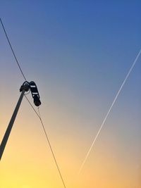 Low angle view of silhouette electricity pylon against sky