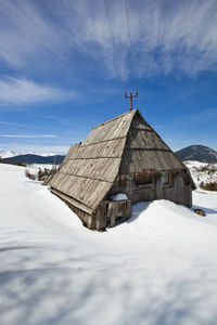 Houses on snowcapped mountain against sky