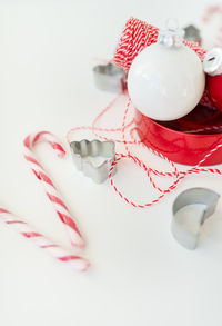 Christmas decorations and a red thread for wrapping gifts lie on a white table. new year 2023-2024