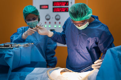 Surgeons operating patient in hospital