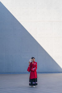 Rear view of woman standing against wall