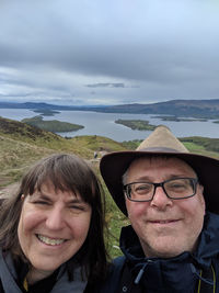 Portrait of smiling mature couple against river