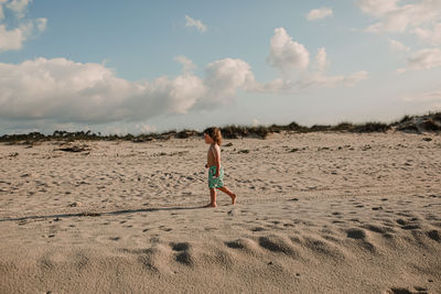 Full length of woman on beach against sky