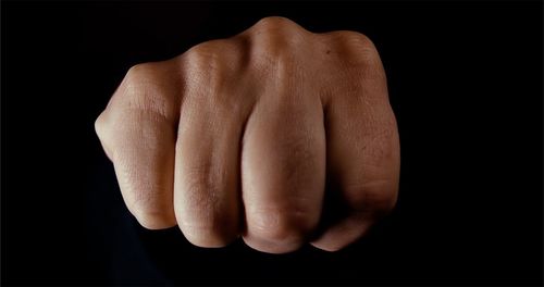 Close-up of human hand against black background