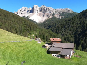 Scenic view of field and houses against mountains