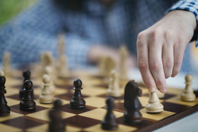 Playing chess. hand of a male chess player moving the white chess piece.