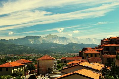 Houses by mountains against sky