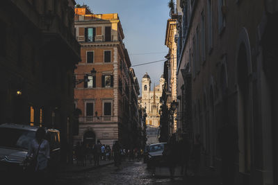 People walking on road along built structures