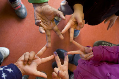 Directly above view of children making star shape from fingers