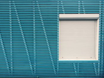 Closed white window on patterned blue wall