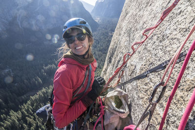 A young woman smiles while at a hanging belay on washington column