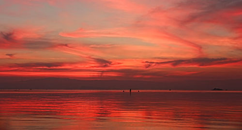 Scenic view of sea against dramatic sky during sunset