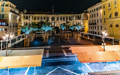 View of swimming pool in city at night