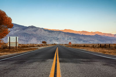 Road by mountains against clear sky