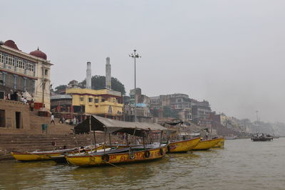 Boats in sea against buildings in city