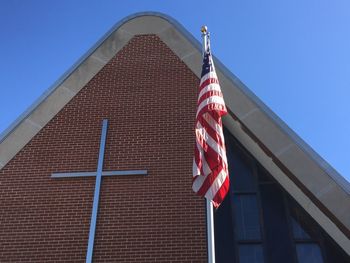 Low angle view of american flag against church
