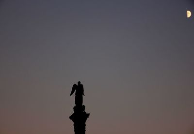 Low angle view of silhouette statue against sky during sunset