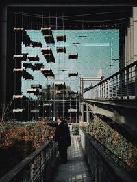 Rear view of people walking on footbridge