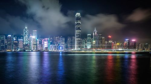 Victoria harbor against illuminated modern buildings