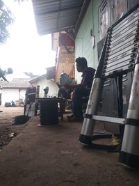 People sitting in front of buildings against the sky