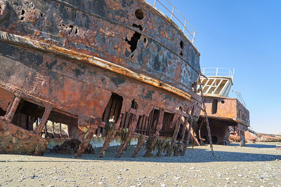 Old rusty and rotten ship wreck with holes in carcass, lying st the strait of magellan in patagonia