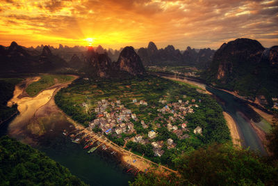 High angle view of trees on landscape against sky during sunset