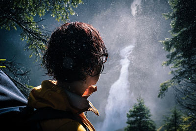 Close-up of man looking at waterfall