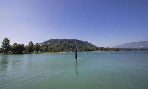 Scenic view of lake against clear blue sky