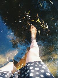 Low section of woman standing in water