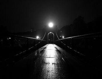 Illuminated bridge against sky at night