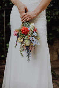 Midsection of woman holding bouquet