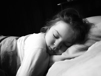 Close-up of girl sleeping on bed at home