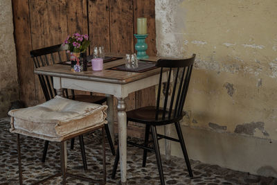 Empty chairs and table against wall at home