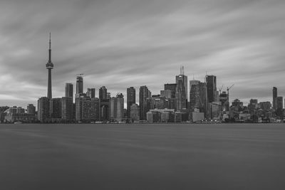 Modern buildings in city against cloudy sky