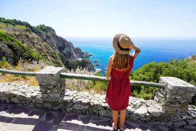 Full body of young woman with hat in capo vaticano on the coast of the gods, calabria, italy.