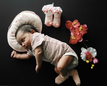 Full length of cute baby girl sleeping by flowers