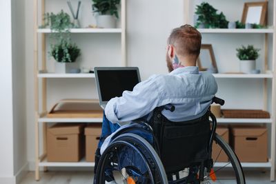 Side view of woman using laptop while sitting on table