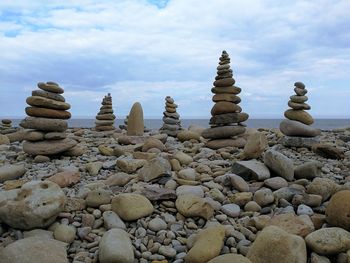 Stack of stones on beach against sky