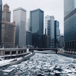 Frozen river by skyscrapers