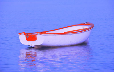 Red boat moored in sea