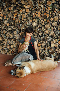 Female woodworker resting with pets while sitting on the floor