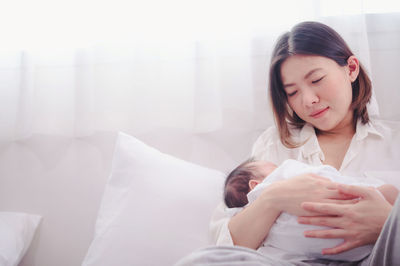 Happy woman lying down on bed