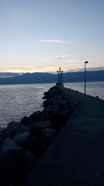 Scenic view of rocks on beach against sky during sunset