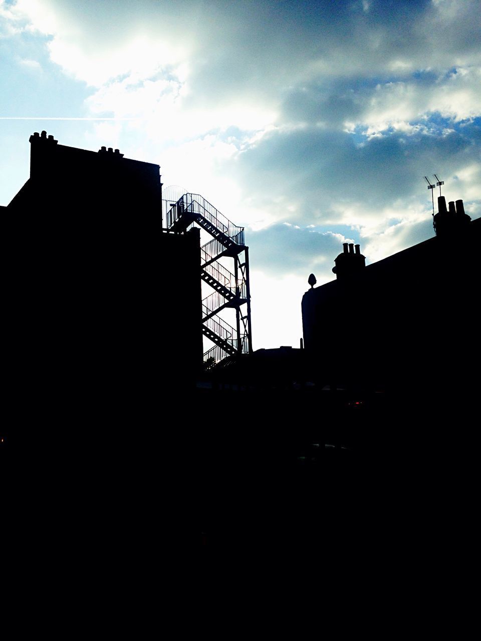 SILHOUETTE OF FACTORY AGAINST SKY