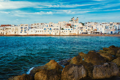 Scenic view of sea by buildings against sky