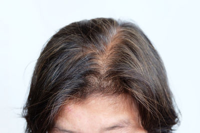 Close-up portrait of woman against white background
