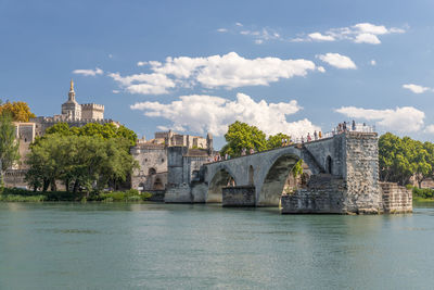 Arch bridge over river against buildings in city