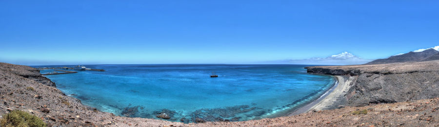 Scenic view of sea against blue sky