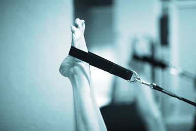 Low section of woman stretching resistance band in gym 